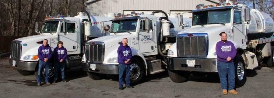 The John's Septic Service crew standing with the company's pump-truck fleet